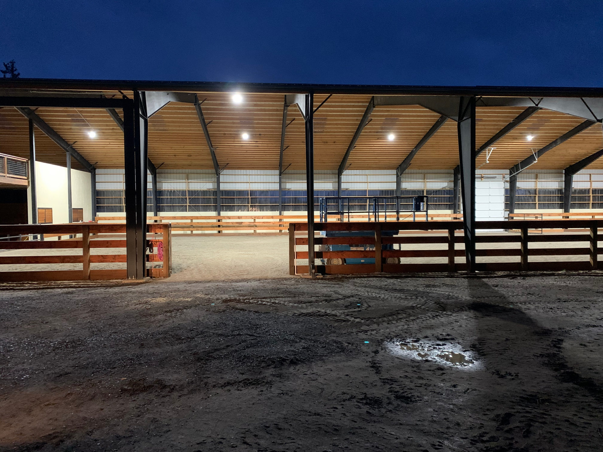 Covered equestrian arena lit at dusk with LED fixtures installed by Pro Electric
